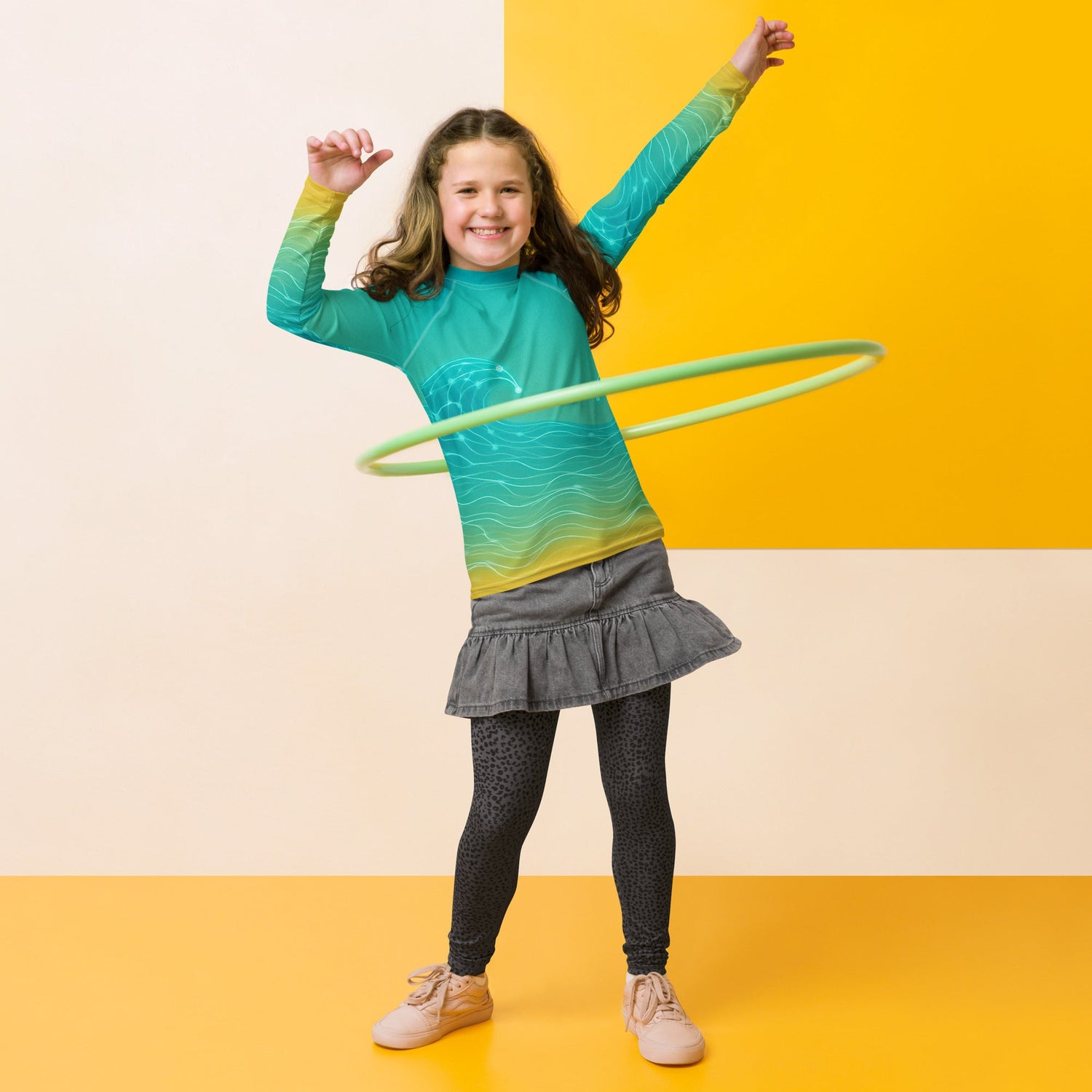 Young girl with rash guard having fun hula-hooping